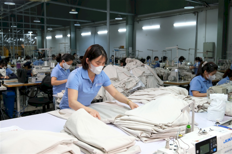 Worker inspecting fabric quality of a uniform shirt